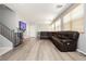 Open living area featuring hardwood floors, a comfortable sectional, and a staircase with a safety gate at 561 Fork Mesa Ct, Henderson, NV 89015