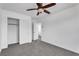 A bedroom with carpet and a ceiling fan and two closets, one with a hanging rack at 576 Foster Springs Rd, Las Vegas, NV 89148