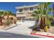 Two story tan home with desert landscaping and palm trees at 576 Foster Springs Rd, Las Vegas, NV 89148