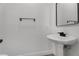 View of a half bathroom featuring a pedestal sink and modern towel rack at 576 Foster Springs Rd, Las Vegas, NV 89148