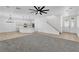 Open concept living room with pendant lighting, and access to the stairwell and front door at 576 Foster Springs Rd, Las Vegas, NV 89148