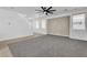 Spacious living room with gray carpet, white walls, and modern ceiling fan at 576 Foster Springs Rd, Las Vegas, NV 89148