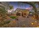 Beautiful backyard with brick patio, artificial grass, fire pit, ambient lighting, and mature trees at 5823 Falling Stream Ave, Las Vegas, NV 89131