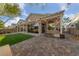 Beautiful backyard featuring a covered patio, fire pit, and well-manicured lawn at 5823 Falling Stream Ave, Las Vegas, NV 89131