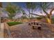 Inviting backyard with artificial turf and a custom brick patio with a stone table at 5823 Falling Stream Ave, Las Vegas, NV 89131