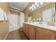 Well-lit bathroom features a double sink vanity and shower-tub combo at 5823 Falling Stream Ave, Las Vegas, NV 89131