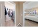 Hallway view of bedroom and walk-in closet with white walls and tan carpet at 5823 Falling Stream Ave, Las Vegas, NV 89131