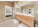 Bright main bathroom with double vanity, framed mirror, and doorway view to Primary bedroom at 5823 Falling Stream Ave, Las Vegas, NV 89131