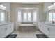 Luxurious bathroom featuring dual vanities, a soaking tub, and an abundance of natural light at 6131 Rio Vista St, Las Vegas, NV 89130