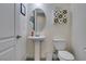 Powder room features a pedestal sink, round mirror, toilet, and storage at 6131 Rio Vista St, Las Vegas, NV 89130