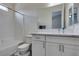 Bathroom featuring quartz counters, white cabinets, and a tub with white tile surround at 6131 Rio Vista St, Las Vegas, NV 89130