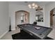 Bright game room featuring a pool table, modern light fixture and arched doorways to other rooms at 6131 Rio Vista St, Las Vegas, NV 89130