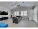 Bright living room features tile floors, a modern sectional couch, media center and large windows at 6131 Rio Vista St, Las Vegas, NV 89130