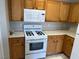 Cozy kitchen featuring wooden cabinets, white appliances, and plenty of natural light at 6170 E Sahara Ave # 1012, Las Vegas, NV 89142