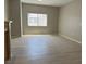 Bright living room with wood-look floors, fresh paint, and a large window that allows natural light at 6170 E Sahara Ave # 1012, Las Vegas, NV 89142