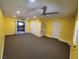 Open living room with neutral carpet, bright yellow walls, and adjacent kitchen access at 6231 Santa Maria Ave, Las Vegas, NV 89108