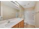 Well-lit bathroom with white shower-tub combo, a light wood vanity, and an oversized mirror at 6255 W Arby Ave # 258, Las Vegas, NV 89118