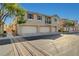Charming townhome showcases a three car garage and neutral stucco exterior under a bright blue sky at 6255 W Arby Ave # 258, Las Vegas, NV 89118