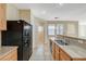 Kitchen view featuring granite countertops, stainless steel sink, and black appliances at 6255 W Arby Ave # 258, Las Vegas, NV 89118