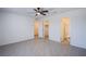 An airy bedroom is featured with modern ceiling fan, tile flooring and bathroom and closet access at 6288 Dolosonte St, Las Vegas, NV 89113