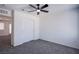 This carpeted bedroom has a ceiling fan, a closet with sliding doors, and overlooks other rooms at 6288 Dolosonte St, Las Vegas, NV 89113