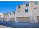 Modern townhome showcasing neutral stucco, attached garage, and a contemporary architectural style under a clear blue sky at 6288 Dolosonte St, Las Vegas, NV 89113