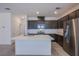 Modern kitchen features stainless steel appliances, a central island with quartz countertops, and dark wood cabinetry at 6288 Dolosonte St, Las Vegas, NV 89113