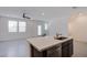 Contemporary kitchen showcasing quartz countertops, dark wood cabinetry, and modern appliances, flowing into a bright living area at 6288 Dolosonte St, Las Vegas, NV 89113