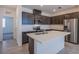 Stylish kitchen with stainless steel appliances, quartz countertops, and dark cabinets, adjacent to a doorway leading to another room at 6288 Dolosonte St, Las Vegas, NV 89113
