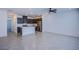 Open living area featuring a modern kitchen with a quartz island and stainless appliances, offering a seamless living experience at 6288 Dolosonte St, Las Vegas, NV 89113