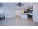 Spacious living area with gray tile flooring, recessed lighting, and an open-concept layout to the kitchen and staircase at 6288 Dolosonte St, Las Vegas, NV 89113