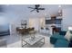 Open-concept living space with stylish furniture, including a dining set, kitchen island seating, and a cozy teal sofa at 6288 Dolosonte St, Las Vegas, NV 89113
