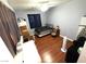 Cozy bedroom with hardwood floors, ceiling fan, and dark curtains at 6351 Davidson Ct, Las Vegas, NV 89110