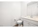 Compact half-bathroom features a wood floor, toilet, and vanity with mirror and vanity lights at 6425 Classic Ridge St, North Las Vegas, NV 89086