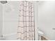 White bathroom features a tub with shower and a white and gray decorative shower curtain at 6425 Classic Ridge St, North Las Vegas, NV 89086