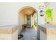 Charming covered front porch featuring an arched entrance, stylish exterior lighting, and space for seating at 6425 Classic Ridge St, North Las Vegas, NV 89086