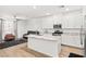 Open kitchen with stainless steel appliances, granite counters, and an island with barstool seating flowing into the living area at 6425 Classic Ridge St, North Las Vegas, NV 89086