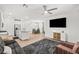 Open-concept living room with hardwood floors, ceiling fan, large TV, and abundant natural light at 6425 Classic Ridge St, North Las Vegas, NV 89086