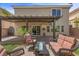 Backyard featuring an outdoor lounge area with a pergola, desert landscaping, and synthetic grass at 6540 W Cougar Ave, Las Vegas, NV 89139