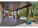 Covered backyard patio with desert landscaping, ample seating, and mature foliage for privacy at 6540 W Cougar Ave, Las Vegas, NV 89139