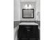 Modern bathroom vanity with black cabinets, white countertop, and square mirror framed with a bold black at 6540 W Cougar Ave, Las Vegas, NV 89139