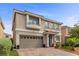 Two-story home with desert landscaping and a brick driveway and walkway at 6540 W Cougar Ave, Las Vegas, NV 89139