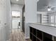 Hallway with gray wood floors, built-in shelving, and laundry room featuring updated machines and storage at 6540 W Cougar Ave, Las Vegas, NV 89139