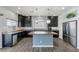 Well-lit kitchen featuring stainless steel appliances, sleek dark cabinetry, and a functional kitchen island at 6540 W Cougar Ave, Las Vegas, NV 89139