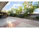 Large backyard with concrete patio, surrounded by mature trees and greenery at 6608 Burgundy Way, Las Vegas, NV 89107