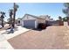 A single story house with a two car garage and desert landscaping and a long driveway at 6929 Montcliff Ave, Las Vegas, NV 89147