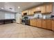 The kitchen features stainless steel appliances, granite countertops and tile flooring at 6929 Montcliff Ave, Las Vegas, NV 89147