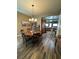 Inviting dining area with wood floors, a cozy round table under a chandelier, and seamless flow into kitchen at 7524 Midnight Rambler St, Las Vegas, NV 89149