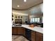 Open kitchen featuring wood cabinets, quartz countertops, black appliances, and seamless flow into the living area at 7524 Midnight Rambler St, Las Vegas, NV 89149
