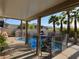 Covered swimming pool area with patio, pool safety fence, and lush palm trees at 7524 Midnight Rambler St, Las Vegas, NV 89149